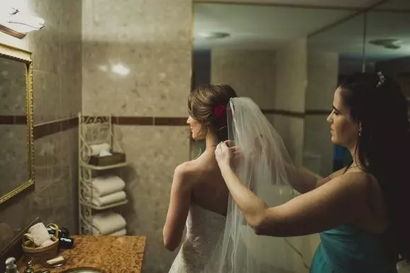 Veil or Not to Veil? 11 Bride fixing her veil